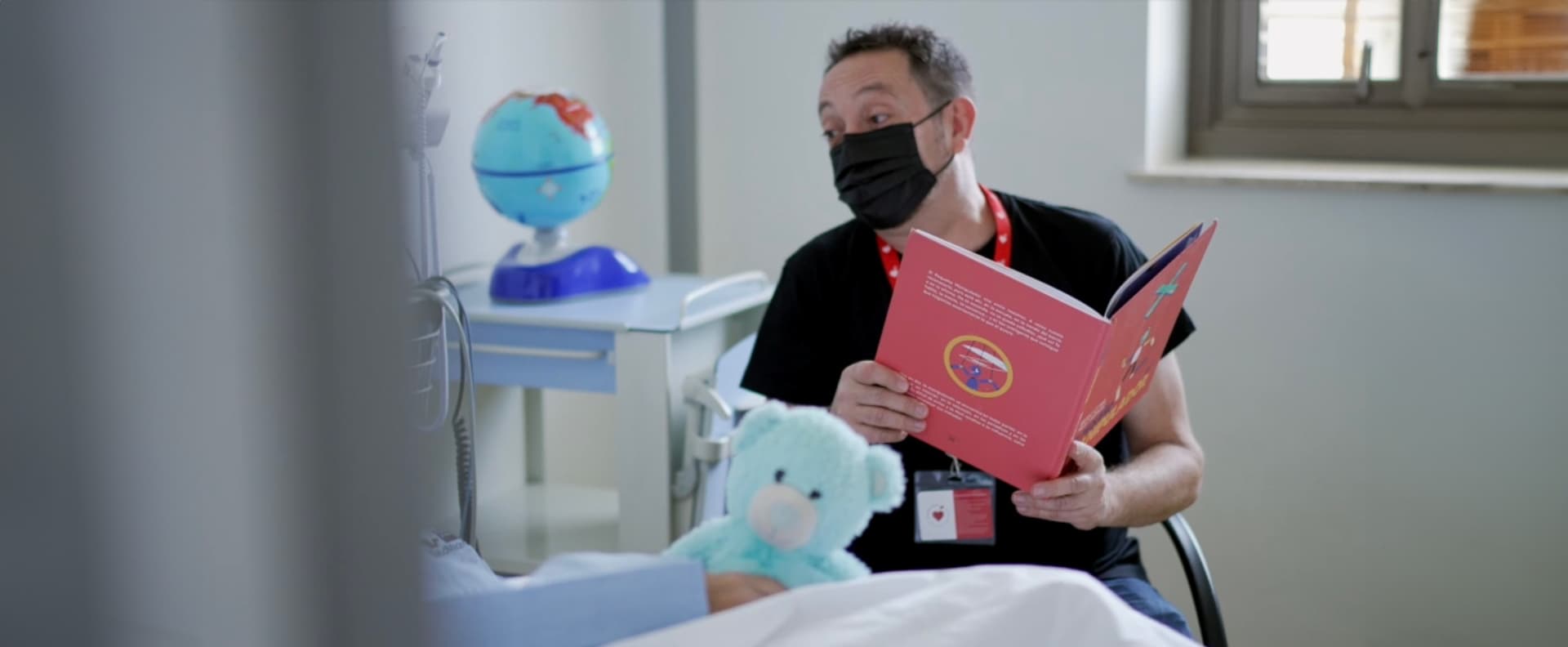 Voluntario de Mamás en Acción acompañando a un niño hospitalizado